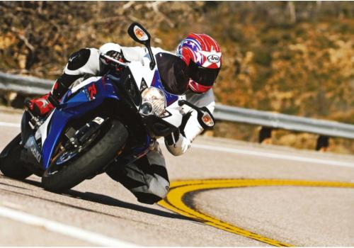 A man takes a tight turn on a motorcycle
