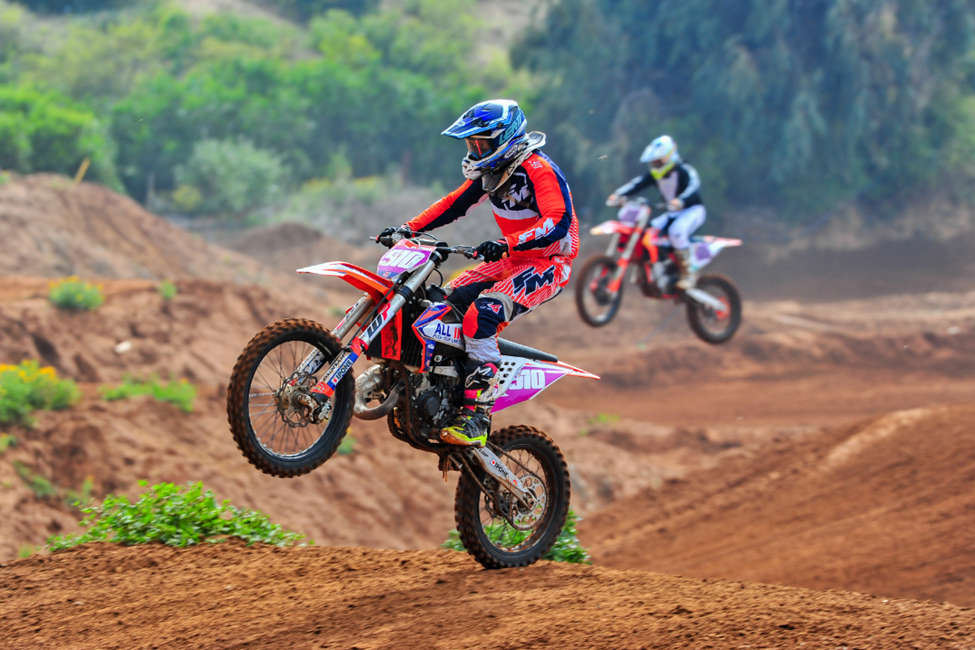 Two men riding dirt bikes on a course